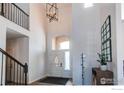 Bright foyer with a high ceiling, elegant chandelier, staircase, and decorative accents at 3214 Timeless Trl, Berthoud, CO 80513