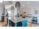 Spacious kitchen with granite countertops, stainless steel appliances, a central island, and stylish pendant lighting at 3214 Timeless Trl, Berthoud, CO 80513