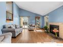 Bright living room with vaulted ceilings, wood floors, fireplace, and sliding glass door to outdoor at 3545 W 132Nd Pl, Broomfield, CO 80020