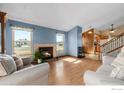 Comfortable living room featuring a fireplace, hardwood floors, and bright windows at 3545 W 132Nd Pl, Broomfield, CO 80020
