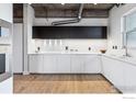 Sleek, modern kitchen featuring white cabinets, stainless steel appliances, and hardwood flooring at 3701 Arapahoe Ave # 309, Boulder, CO 80303
