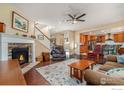 Inviting living room features a stone fireplace, ceiling fan, and open access to the kitchen at 4679 Lakeside Dr, Longmont, CO 80504