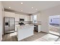 Modern kitchen featuring white cabinets, stainless steel appliances, and a functional island at 4846 Astor Pl, Brighton, CO 80601