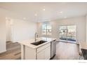 Bright kitchen featuring an island, stainless steel dishwasher, and sliding glass doors at 4847 Astor Pl, Brighton, CO 80601