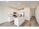 Modern kitchen with white cabinets, stainless steel appliances, and a center island at 4847 Astor Pl, Brighton, CO 80601