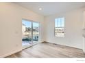 Bright living room with a view to the outside featuring a large window and sliding door at 4847 Astor Pl, Brighton, CO 80601