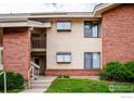Beautiful condo building with well-manicured lawn and a combination of siding and brick at 595 Manhattan Dr # 203, Boulder, CO 80303