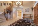 Inviting foyer with staircase, chandelier, and decorative rug creating an elegant entryway at 630 S Snowmass Cir, Superior, CO 80027