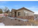 Charming single-story house featuring stone accents and drought-resistant landscaping on a sunny day at 6981 Buckskin Dr, Littleton, CO 80125