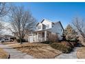 Inviting home featuring a porch, mature trees, and neat landscaping at 11499 Kenton St, Commerce City, CO 80640