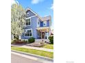 Charming two-story blue home with a blossoming tree in the front yard, creating a picturesque curb appeal at 1526 Haystack Way, Lafayette, CO 80026