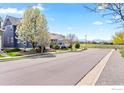 Beautiful street view of upscale homes, manicured lawns, and mountain backdrop on a sunny day at 1526 Haystack Way, Lafayette, CO 80026