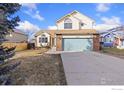 Inviting two-story home featuring a well-manicured lawn and a spacious driveway at 1749 Foster Dr, Longmont, CO 80501