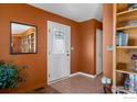 Warm entryway featuring tile flooring, a decorative mirror, and adjacent closet at 2100 Breckenridge Dr, Berthoud, CO 80513