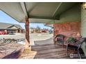 Relaxing front porch featuring comfortable seating and decorative stone accents at 2100 Breckenridge Dr, Berthoud, CO 80513