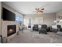 Cozy living room with a fireplace, plush seating, and lots of natural light through the windows at 2800 Blue Sky Cir # 208, Erie, CO 80516