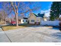 Charming home with a yellow exterior, a green roof, and a concrete driveway at 324 Francis St, Longmont, CO 80501