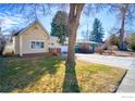 Charming home with a yellow exterior, a well-kept lawn, and a concrete driveway at 324 Francis St, Longmont, CO 80501