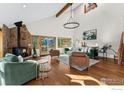 Spacious living room boasts wood floors, vaulted ceilings, stone fireplace, and comfortable seating, filled with natural light at 333 Antler Dr, Boulder, CO 80302