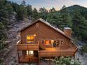 A wood-clad home with multiple decks overlooks a hillside, featuring windows that illuminate the interior at 333 Antler Dr, Boulder, CO 80302