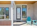 Inviting front porch featuring stylish seating, modern lighting fixtures, and a contemporary glass door entrance at 3633 Paonia St, Boulder, CO 80301