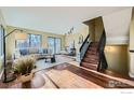 Bright living room with wood floors, neutral walls, and a staircase to the second floor, well lit from the large window at 4647 Dapple Ln, Boulder, CO 80301