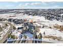 Expansive aerial view of a home surrounded by snowy landscape and neighborhood, and a sport court at 4873 Desperado Way, Parker, CO 80134