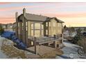Beautiful home featuring a large deck, covered patio, and stone accents, perfect for outdoor living at 4873 Desperado Way, Parker, CO 80134