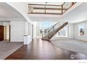 Bright foyer boasts soaring ceilings, hardwood floors, staircase, and ample natural light, creating a grand entrance at 4873 Desperado Way, Parker, CO 80134