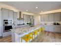 Modern kitchen featuring gray cabinetry, a large island, and stainless steel appliances at 55 Morgan S Cir, Erie, CO 80516