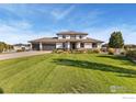 Beautiful two-story home with lush lawn and mature landscaping in a serene neighborhood setting at 6006 E 162Nd Pl, Brighton, CO 80602