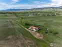 Aerial view showcasing a home on a sprawling green field, surrounded by lush greenery at 8602 N 39Th St, Longmont, CO 80503
