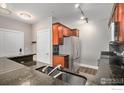 Kitchen featuring stainless steel appliances, dark granite countertops, and wood cabinetry at 9039 E Panorama Cir # 201, Englewood, CO 80112