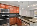 Kitchen featuring stainless steel appliances, dark granite countertops, and wood cabinetry at 9039 E Panorama Cir # 201, Englewood, CO 80112