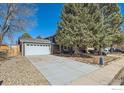 Home featuring a detached garage and extended concrete driveway at 1055 Ponderosa Cir, Longmont, CO 80504