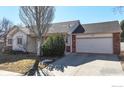 Single-story home with brick accents, attached two-car garage, and well-maintained front yard at 1121 Jefferson Dr, Berthoud, CO 80513