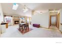 Open living room with vaulted ceilings, skylights, fireplace, and a cozy dining area at 1121 Jefferson Dr, Berthoud, CO 80513