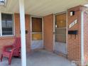 View of the front entrance of the house showing address and a red chair on the covered porch at 117 Valentine Ln, Longmont, CO 80501