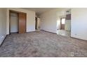 Spacious living room featuring neutral carpet, ample natural light, and a versatile open layout at 117 Valentine Ln, Longmont, CO 80501