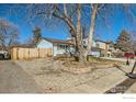 Lovely exterior view of the house with mature tree, partially fenced yard, and convenient driveway at 1317 S Terry St, Longmont, CO 80501