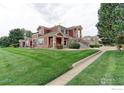 Well-maintained exterior showing the townhome's manicured lawn and convenient parking at 13722 Legend Way # 101, Broomfield, CO 80023