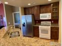 Well-equipped kitchen with granite countertops, stainless steel refrigerator, and modern appliances at 15346 Heritage Cir, Thornton, CO 80602