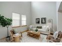 Bright living room featuring high ceilings, neutral decor, and plenty of natural light at 15453 E 109Th Ave, Commerce City, CO 80022