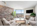 Living room featuring a brick accent wall, expansive city view, and comfortable seating at 1625 Larimer St # 2501, Denver, CO 80202