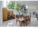 Bright dining area featuring a tall tree, wooden table and chairs, and an adjacent kitchen at 1866 Park Lake Dr, Boulder, CO 80301