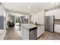 Modern open-concept kitchen featuring stainless steel appliances, granite countertops, and seamless access to the living area at 2719 Tallgrass Ln, Berthoud, CO 80513