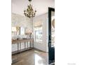 Bright foyer featuring an elegant light fixture, stylish wallpaper, and a console table with mirror at 3182 5Th St, Boulder, CO 80304