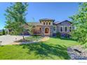 Inviting exterior with stone accents, manicured lawn, and an arched entryway, creating a warm and welcoming curb appeal at 4822 Bandera Pl, Parker, CO 80134