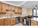 Well-lit kitchen featuring wooden cabinets, modern appliances, and sleek countertops at 491 S Dover Ave, Lafayette, CO 80026