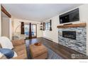 Cozy living room with a modern fireplace, hardwood floors, and a sliding door to the outside at 491 S Dover Ave, Lafayette, CO 80026